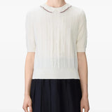 White knitwear worn by a person, showing the knitwear's fit