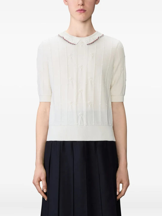 White knitwear worn by a person, showing the knitwear's fit