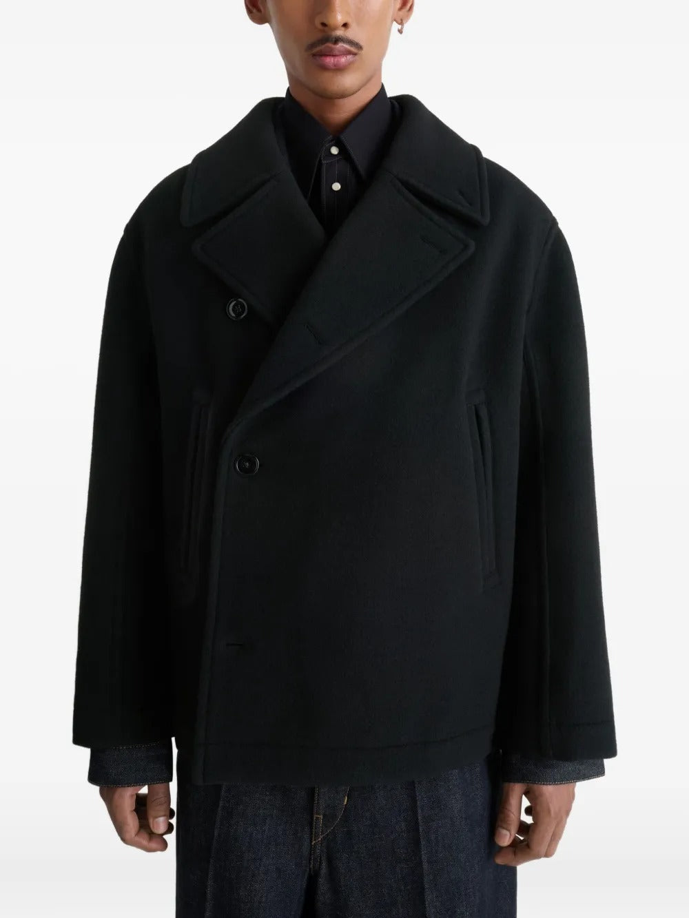 Black coat worn by a person, showing the coat's fit