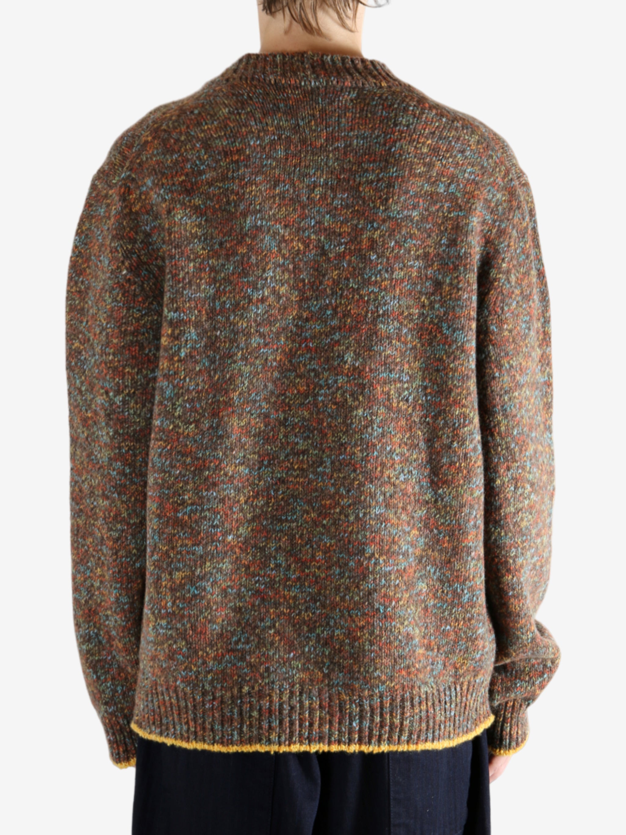Brown knitwear worn by a person, showing the knitwear's fit