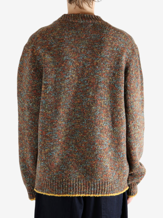 Brown knitwear worn by a person, showing the knitwear's fit