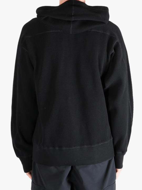 Black hoodie worn by a person, showing the hoodie's fit