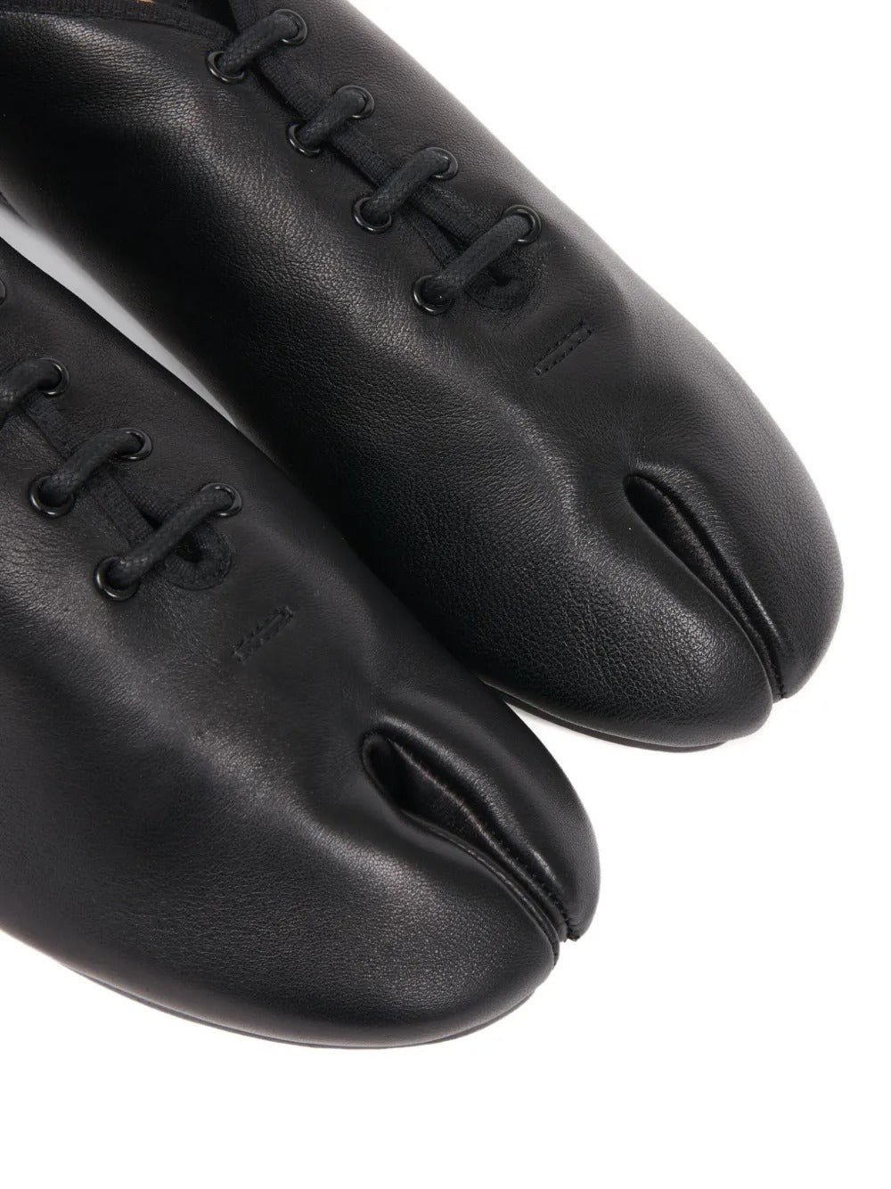 Close up of the black shoes, showing texture of the leather fabric