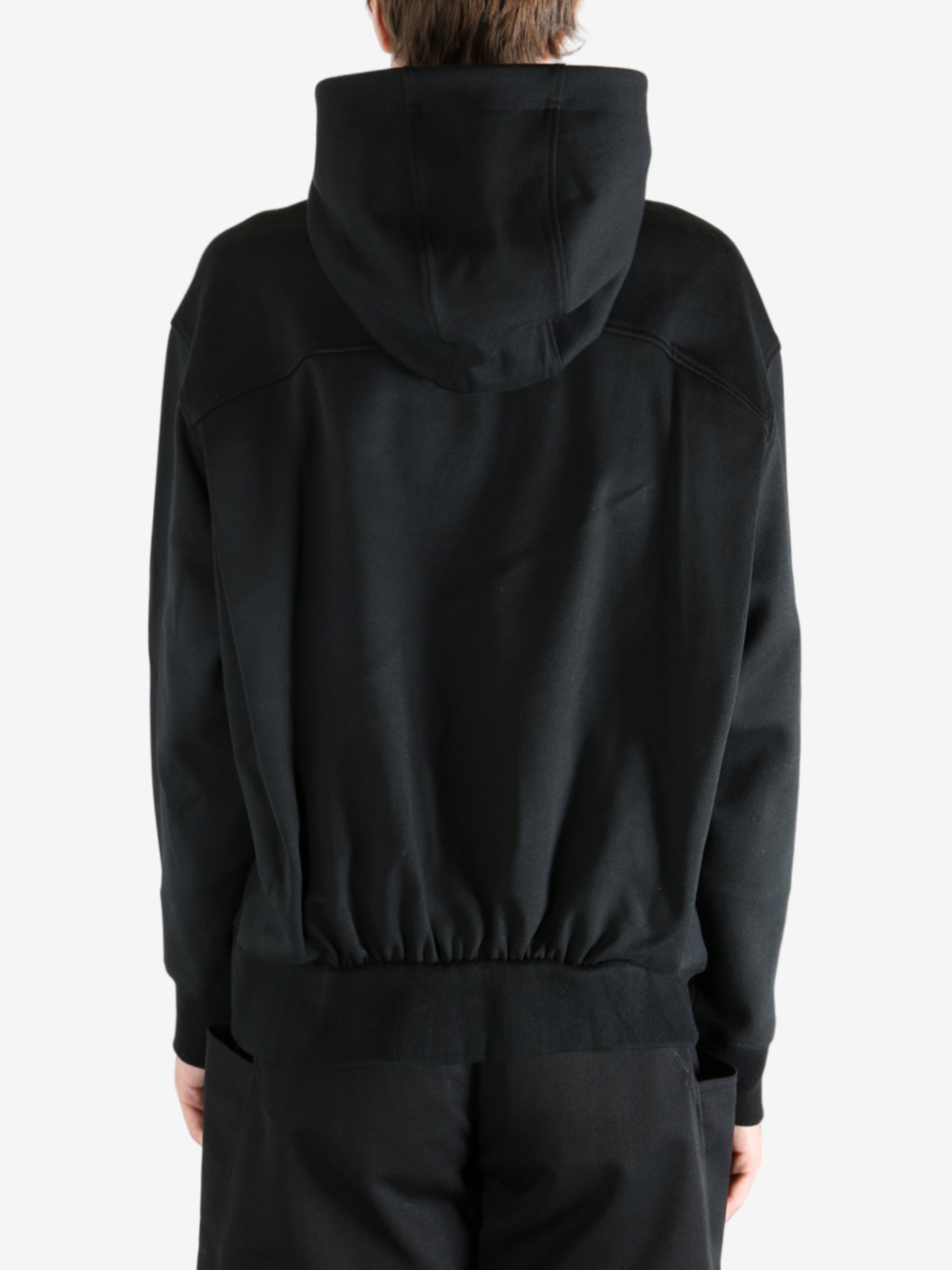 Black hoodie worn by a person, showing the hoodie's fit