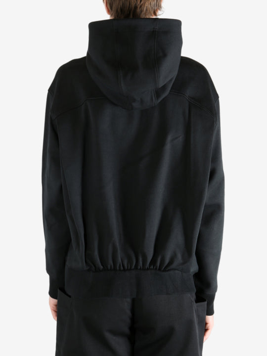 Black hoodie worn by a person, showing the hoodie's fit