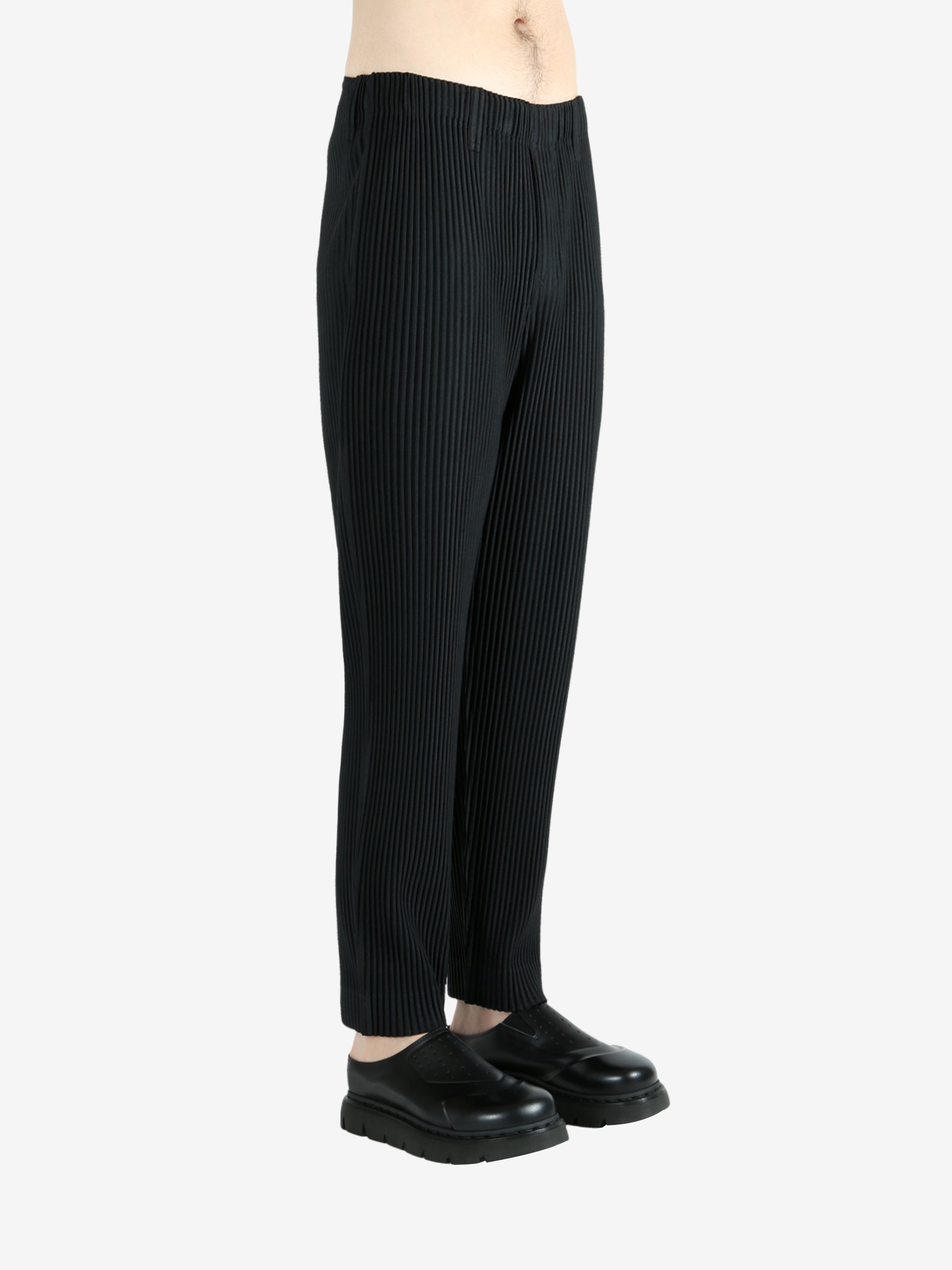 Black pants worn by a person, showing the pants's fit