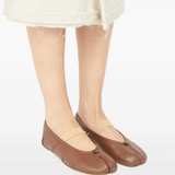 Brown flats worn by a person, showing the flats's fit