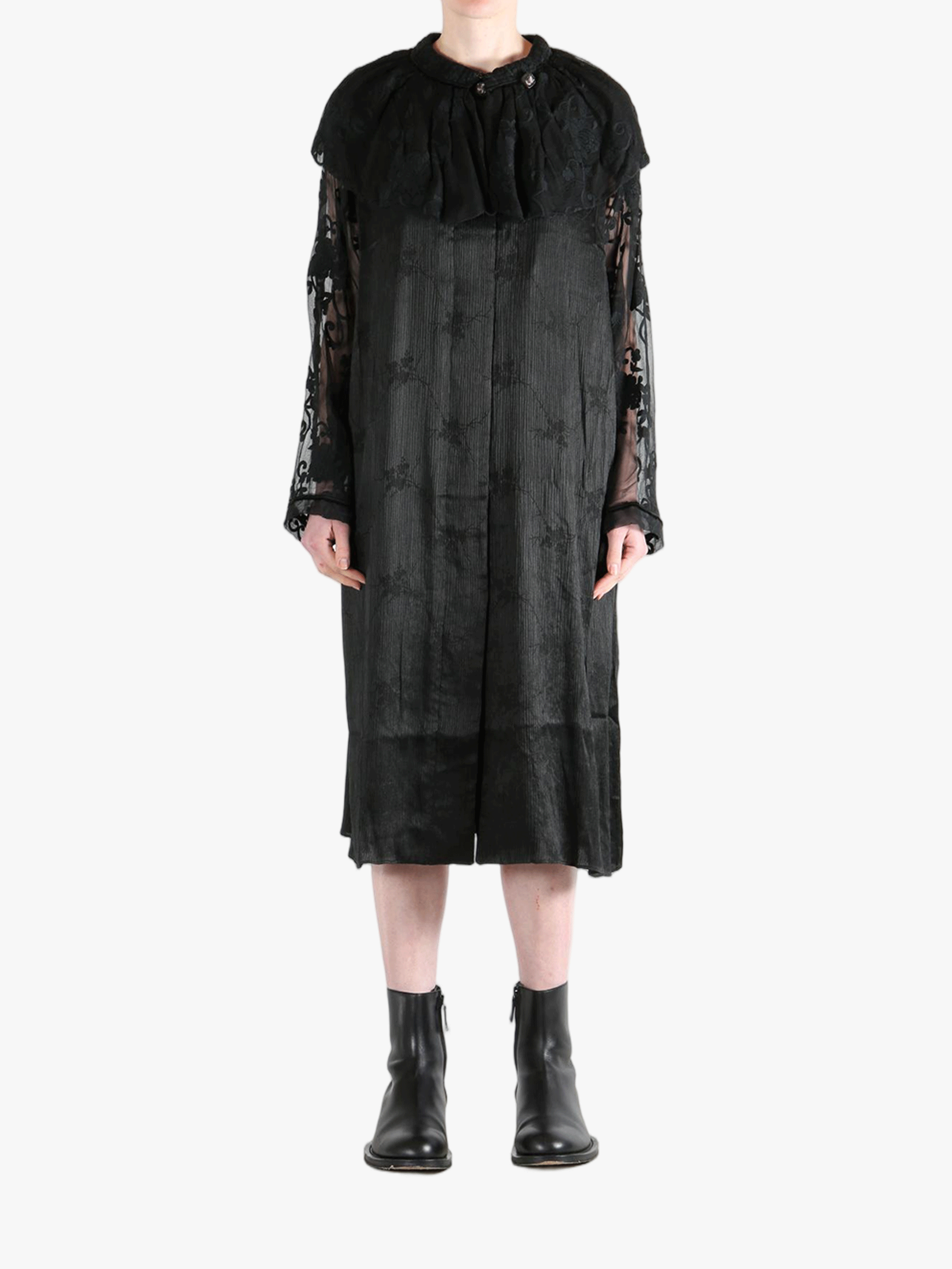 Black coats worn by a person, showing the coat's fit