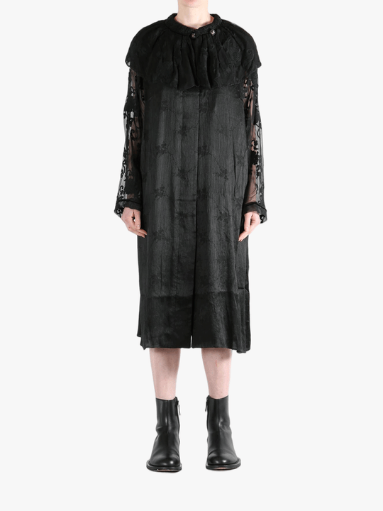 Black coats worn by a person, showing the coat's fit