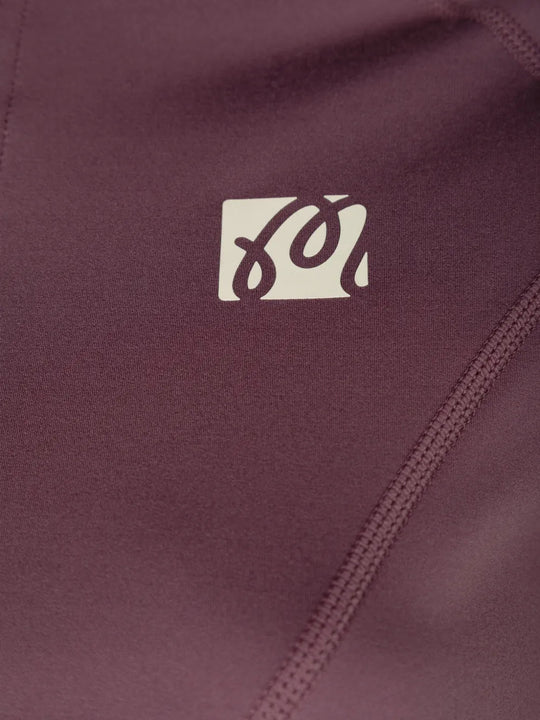 Close up of Burgundy jacket, showing texture of the 66% recycled polyester/ 34% elastane made in fabric