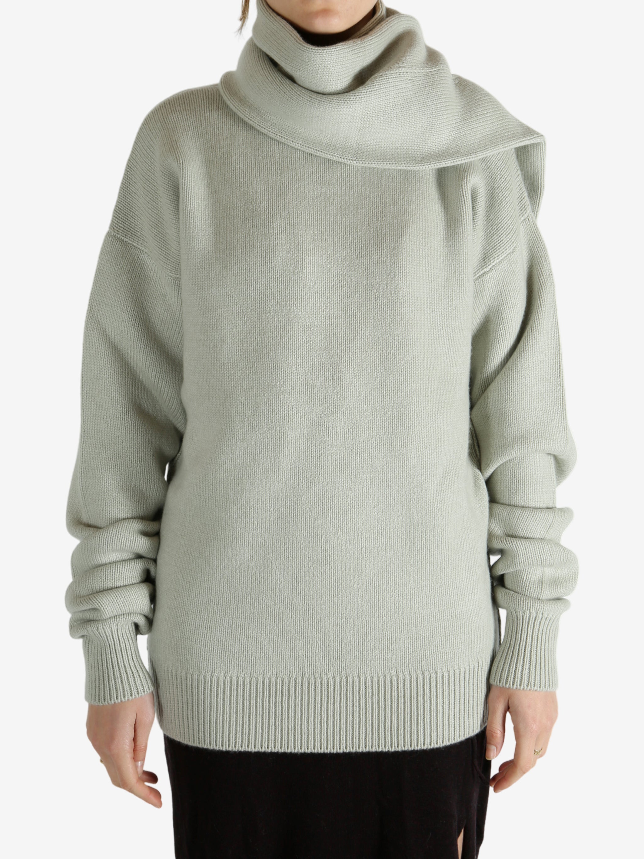 Green knitwear worn by a person, showing the knitwear fit