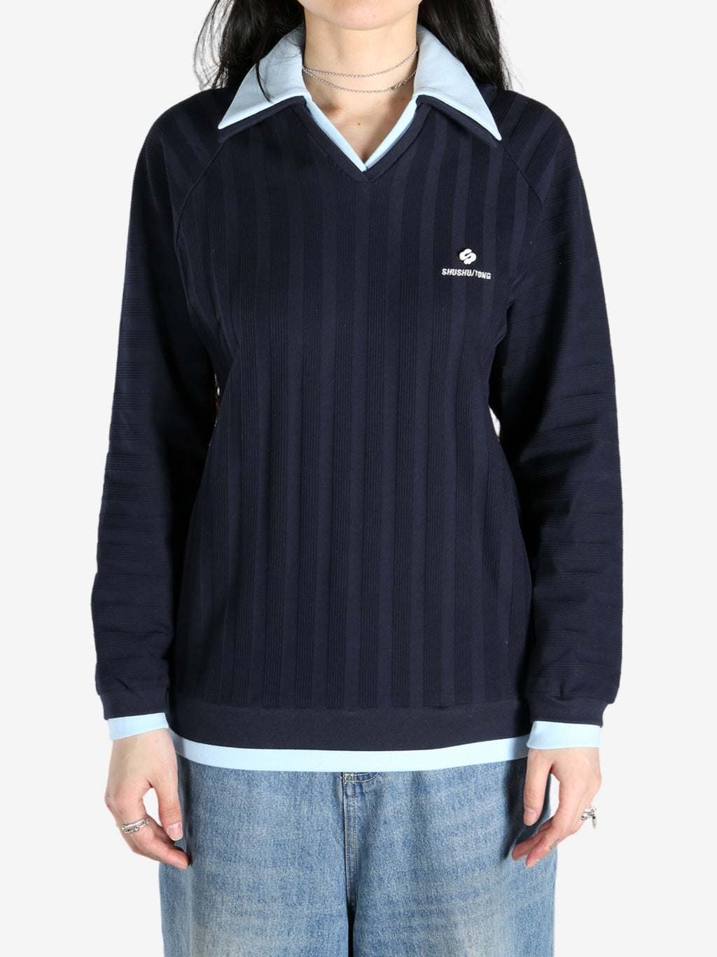 Blue knitwear worn by a person, showing the tops fit