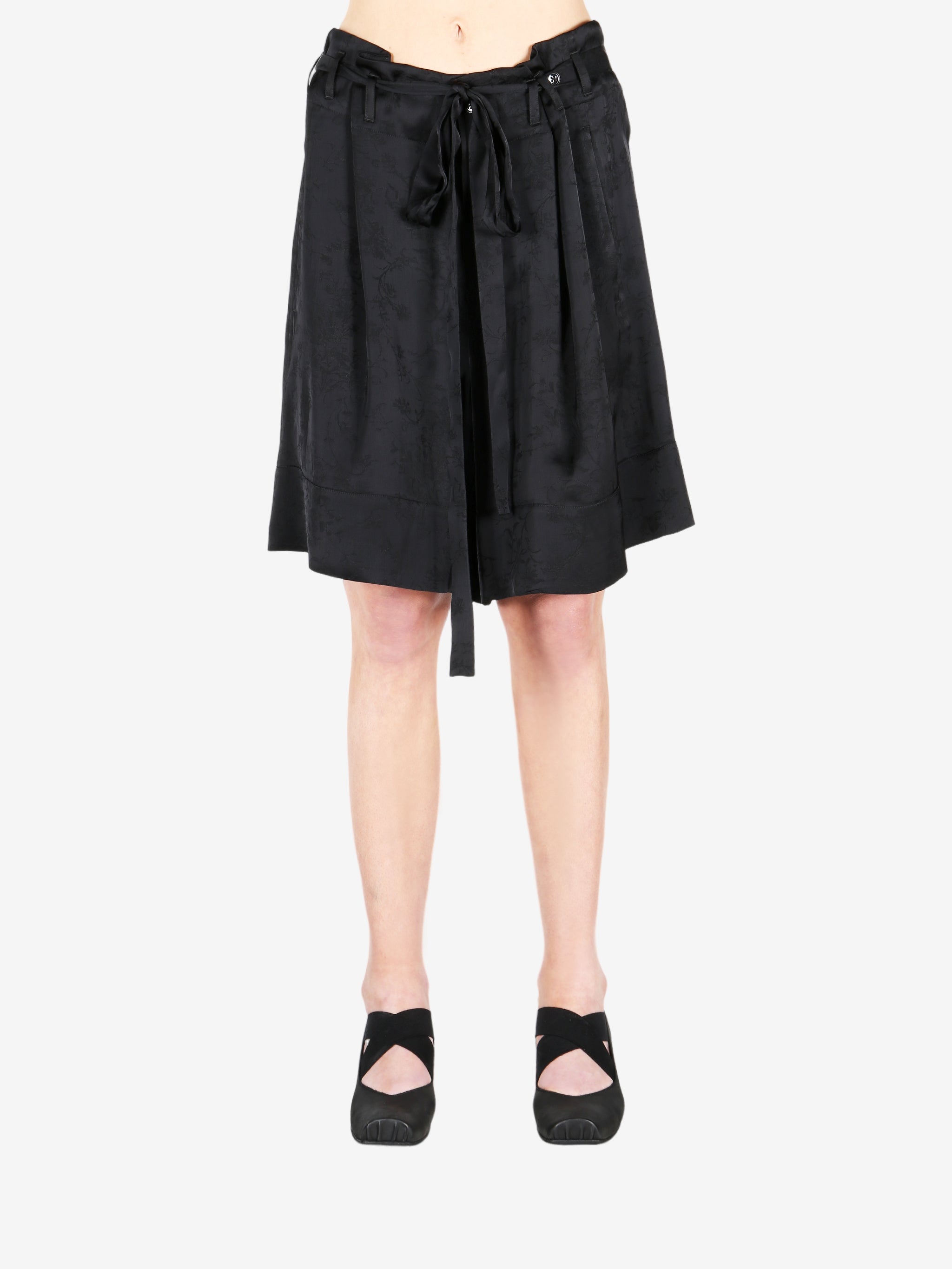 Black pant worn by a person, showing the shirt fit