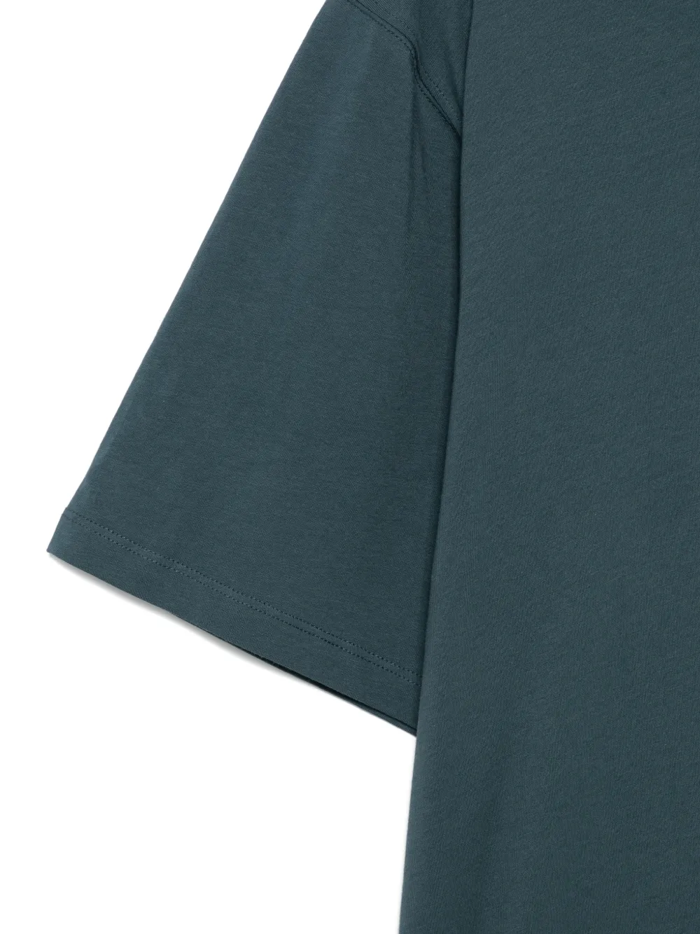 close up of green t-shirts, showing texture of the cotton fabric