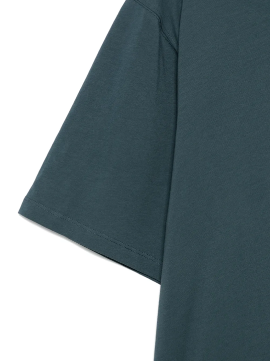 close up of green t-shirts, showing texture of the cotton fabric