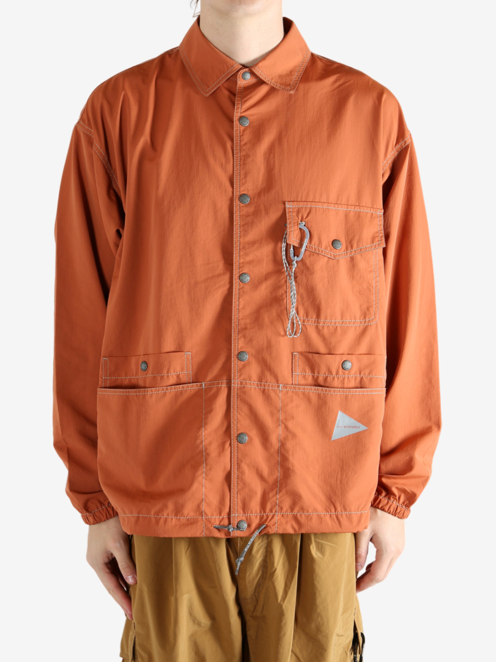 Orange jacket worn by a person, showing the jacket's fit