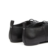 Close up of black shoes, showing texture of the leather and cotton  fabric