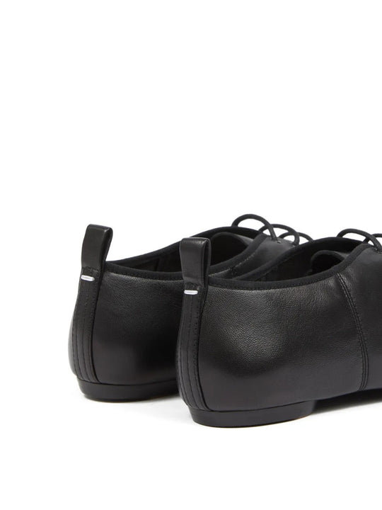 Close up of black shoes, showing texture of the leather and cotton  fabric