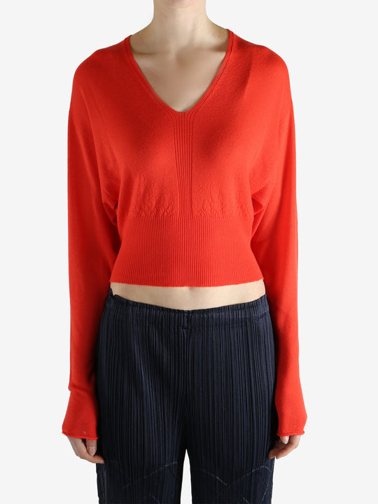 Red long-sleeve top worn by a person, showing the top fit