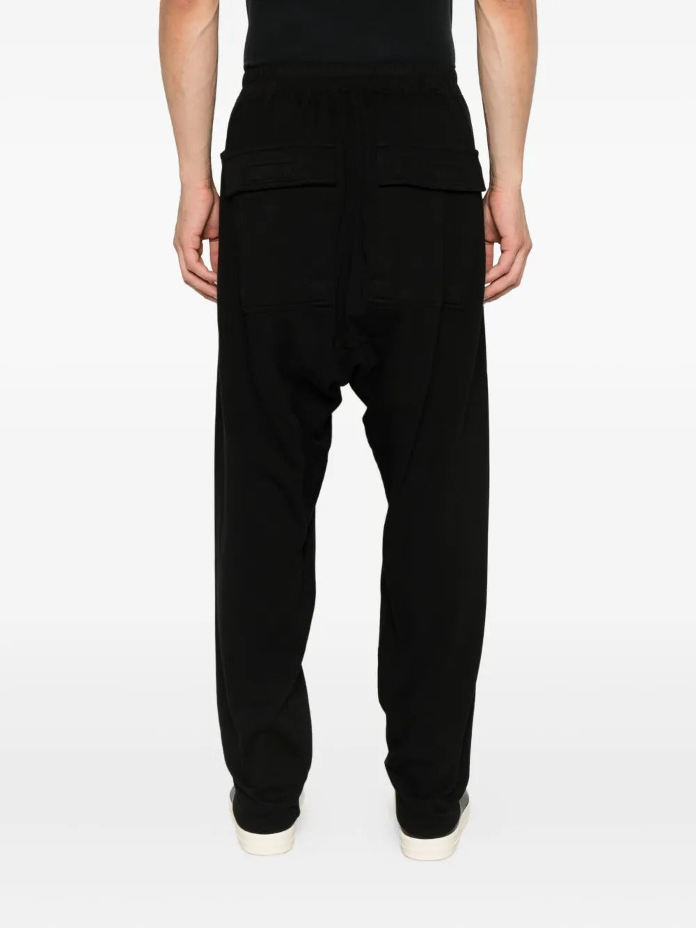 Black pants worn by a person, showing the pants' fit