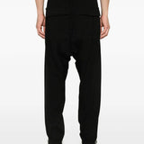 Black pants worn by a person, showing the pants' fit