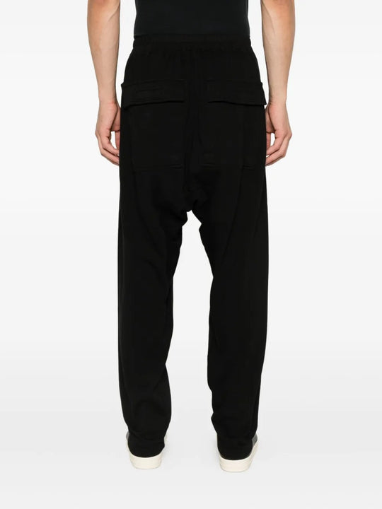 Black pants worn by a person, showing the pants' fit