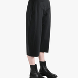 Black pants worn by a person, showing the pants' fit