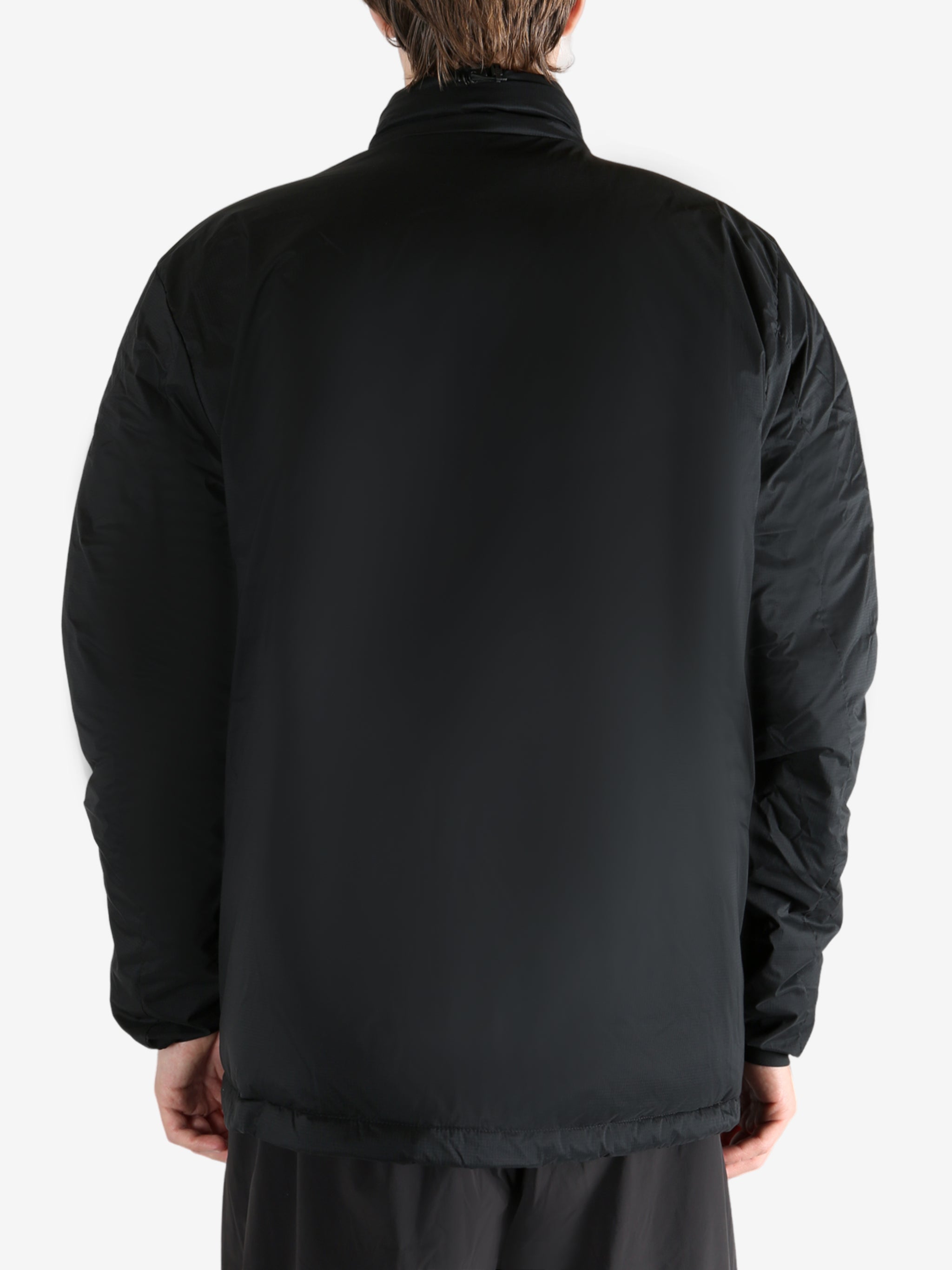 Black jacket worn by a person, showing the coat's fit