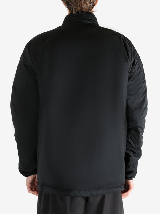 Black jacket worn by a person, showing the coat's fit