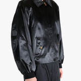 Black satin jacket worn by a person, showing the jacket fit