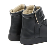 Close up of the black sneakers, showing texture of the calf leather 