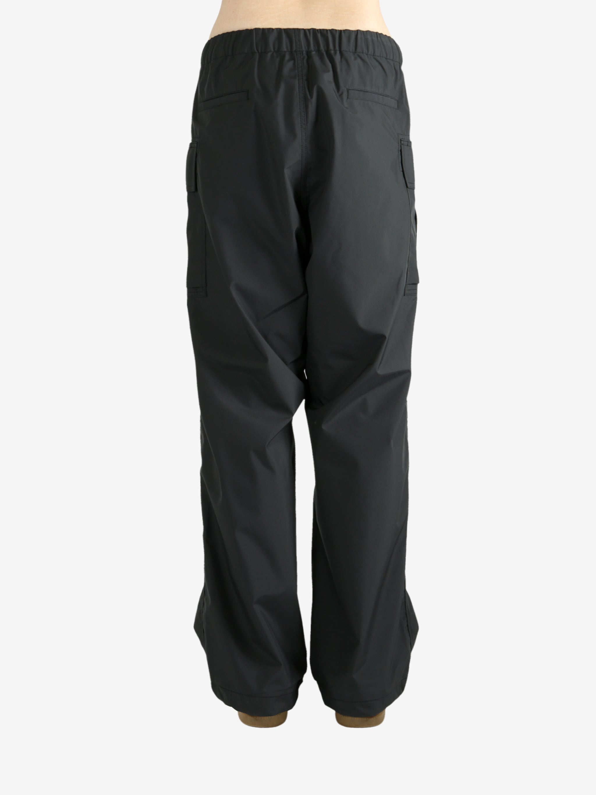 Black pants worn by a person, showing the pants's fit