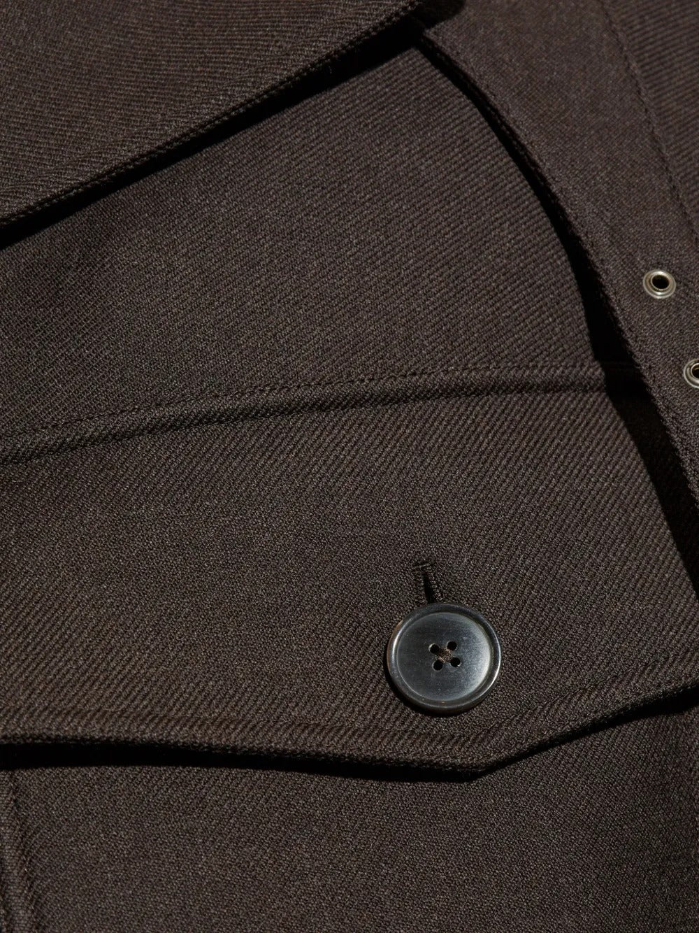 Close up of brown jacket, showing button detail