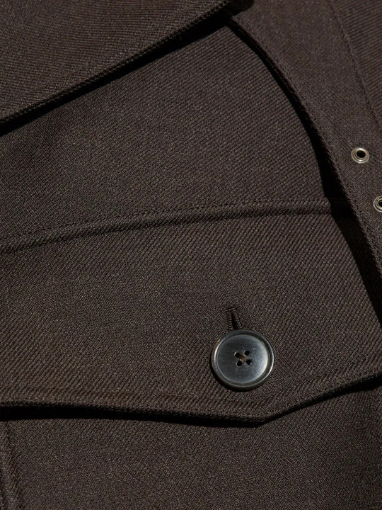 Close up of brown jacket, showing button detail