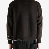 Black sweater worn by a person, showing the sweater's fit