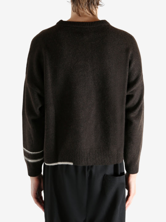 Black sweater worn by a person, showing the sweater's fit