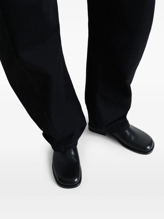 Black shoes worn by a person, showing the shoes fit