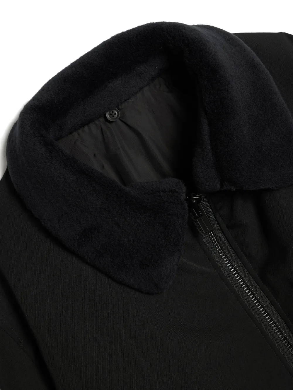 Close up of the black jacket, showing texture of the polyester fabric