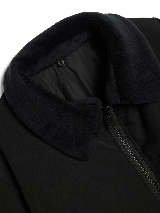 Close up of the black jacket, showing texture of the polyester fabric