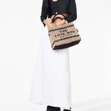 Tan bag carried by a person, showing the bag’s style