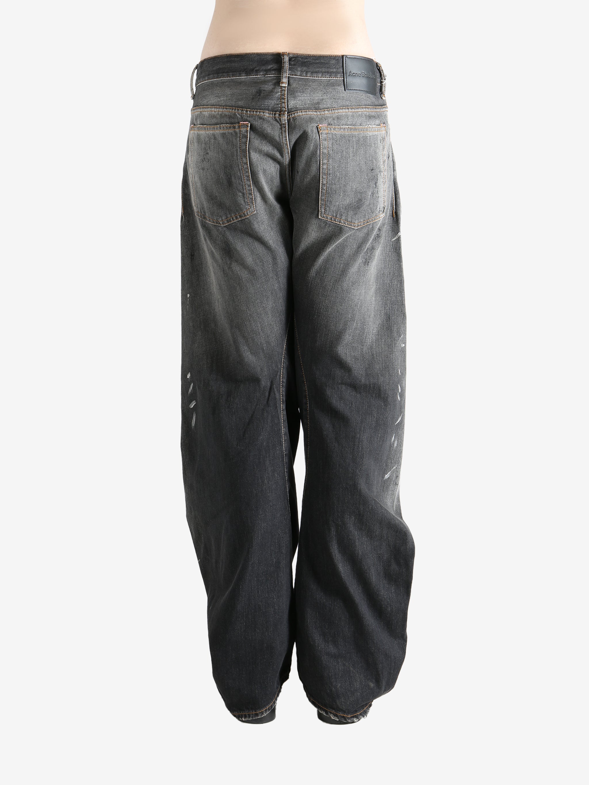 Black jeans worn by a person, showing the jeans fit