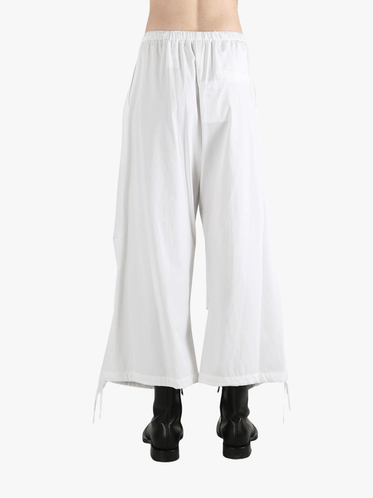 White pants worn by a person, showing the pants' fit