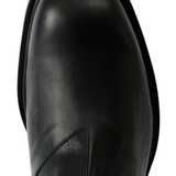 Close up of black boots, showing the detail of claf leather material
