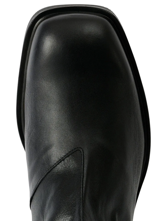 Close up of black boots, showing the detail of claf leather material