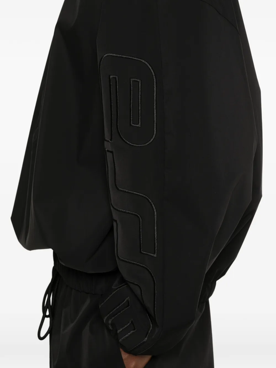 Close up of black coats, showing texture of the polyester fabric