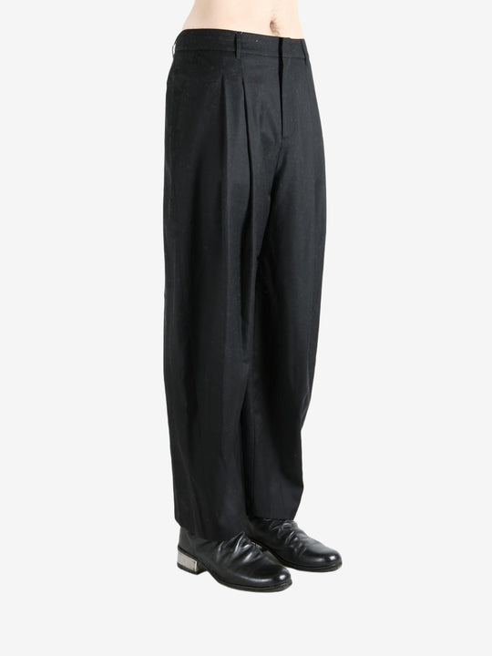 Black pants worn by a person, showing the pants fit