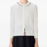 White knitwear worn by a person, showing the knitwear's fit