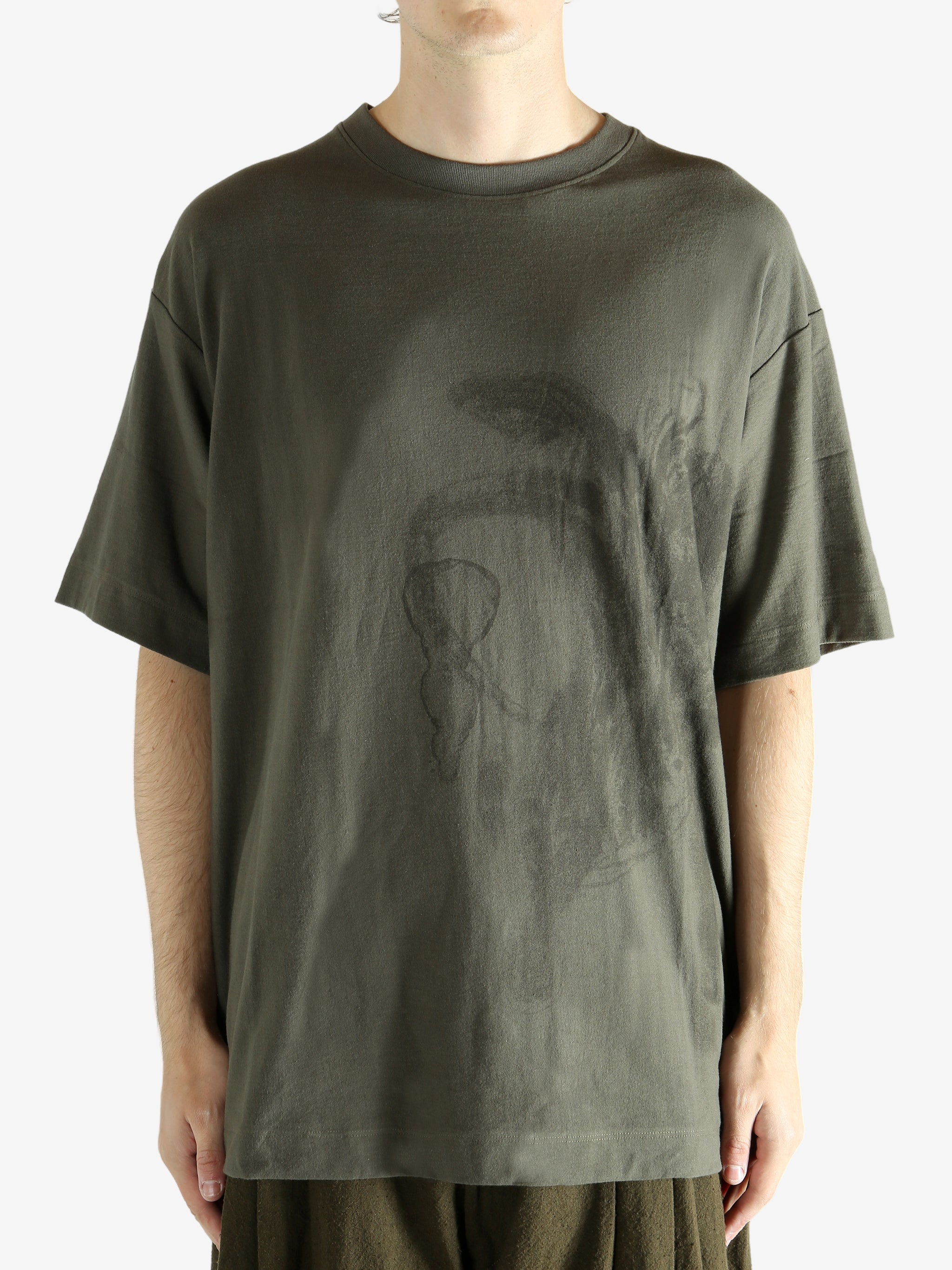 Green t-shirt worn by a person, showing the t-shirt's fit