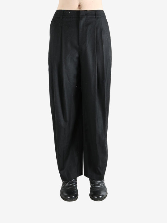 Black pants worn by a person, showing the pants fit