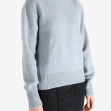 Blue sweater worn by a person, showing the sweater's fit